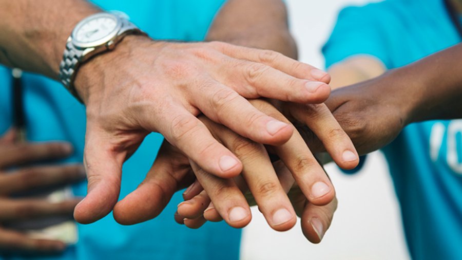 Team of volunteers stacking hands